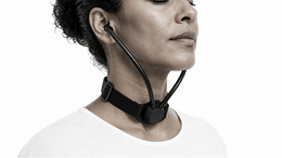 Close-up of a woman wearing Inpulse with the acoustic chamber positioned at the base of her throat.